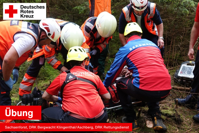 Retterinnen und Retter der Rettungsdienst Oberes Vogtland gGmbH und der DRK Bergwacht Klingenthal/Aschberg heben den verletzten Forstarbeiter auf eine Trage.